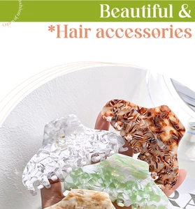 Close-up of marbled acetate hair claws in white, light green, amber, and beige colors