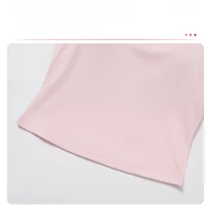 Detailed close-up of light pink fitness top showing double-stitched curved hem and fabric texture