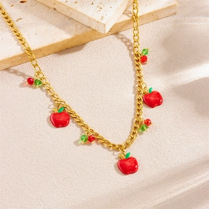 Golden necklace with red apple pendants on a natural stone background, sweet pastoral style