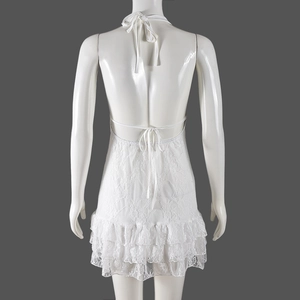 Detailed back view of white lace backless dress featuring halter ties and tiered ruffles