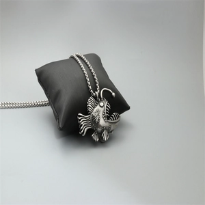 Retro stainless steel anglerfish pendant necklace with textured detail on display