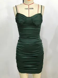 Détail de la robe moulante en satin vert foncé avec fronces et décolleté en cœur