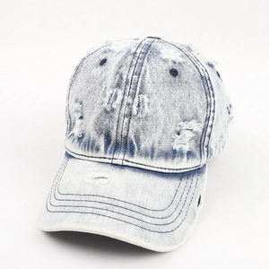 Vintage washed denim baseball cap with distressed torn details and light blue gradient