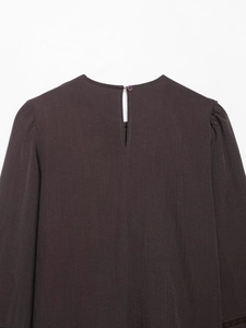 Détail d'un chemisier marron à col rond avec dentelle et fermeture boutonnée