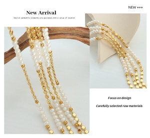 Macro shot of multi-layer gold chain with freshwater pearls and geometric metal discs