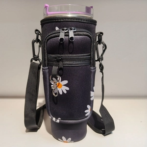 Detail of floral neoprene water bottle carrier with zipper pockets and adjustable strap