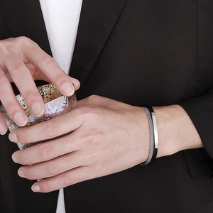 Close-up of stainless steel mesh and leather bracelet with a magnetic clasp on a wrist