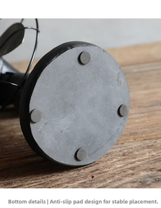 Detailed view of vintage industrial fan base with four non-slip pads on rustic wood