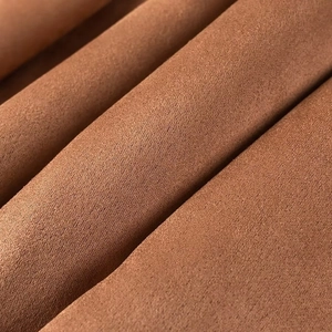 Close-up detail of soft brown faux suede fabric texture for a winter trench coat