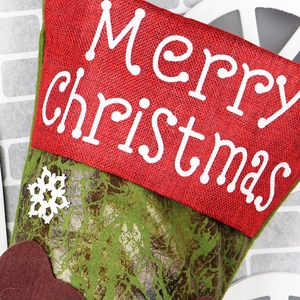 Detail of red and green burlap Christmas stocking with Merry Christmas print and snowflakes