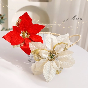 Red and cream artificial Christmas poinsettia flowers in a basket with festive gold details