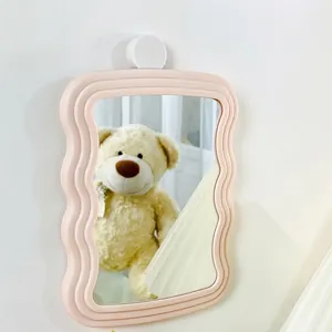 Pink wavy frame wall-mounted vanity mirror for bedroom with minimalist hanging design