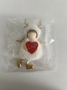 Detailed view of a white plush reindeer ornament holding a red heart with love text