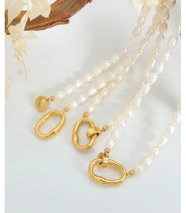 Macro detail of natural freshwater baroque pearls with textured golden geometric clasps