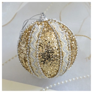 Detail of champagne gold Christmas ball ornament with glitter, silver waves and beads