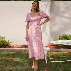 Detail of floral pink midi dress featuring square neck, puff sleeves and satin texture