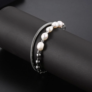 Double-layered stainless steel bracelet with baroque pearls and snake chain on black stand