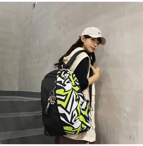 Detail of street style backpack with neon graffiti patterns and side zipper pocket