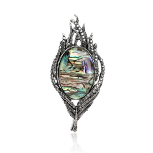 Macro detail of feather brooch with natural abalone shell inlay and vintage silver finish