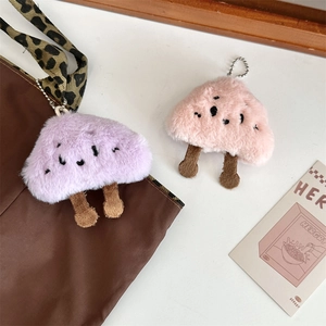 Dettaglio di ciondoli a forma di fungo in peluche morbido su una borsa leopardata