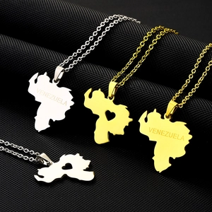 Detail of Venezuela map pendants in gold and silver with heart cutouts and engravings