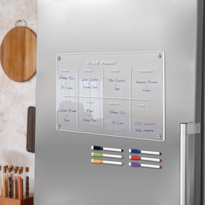 Macro shot of magnetic acrylic weekly planner with six colorful dry erase markers on a fridge