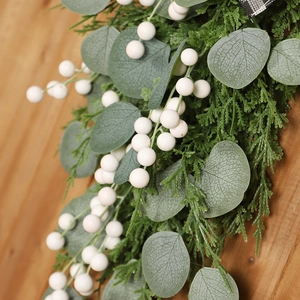 Christmas eucalyptus swag with white berries and green needles on wooden background