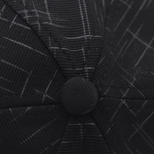 Macro shot of baseball cap crown with black and white grid pattern and top button detail