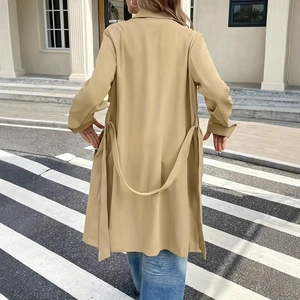 Rear view of khaki trench coat featuring adjustable waist tie belt and longline silhouette