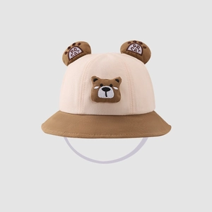 Detailed front view of a cute beige and brown baby bucket hat with cartoon bear design