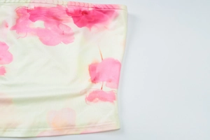 Gros plan sur la maille côtelée crème avec imprimé floral rose et détails de couture