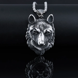 Macro shot of silver wolf head pendant with detailed fur texture and polished steel finish