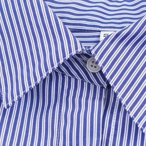 Détail du tissu à rayures bleues et blanches et étiquette de taille S sur la chemise