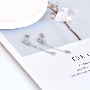 Macro detail of silver tassel earrings with rectangular and marquise-cut cubic zirconia