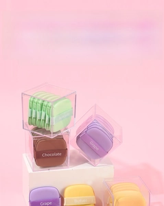 Macro shot of colorful square makeup puffs in clear boxes with silk ribbons