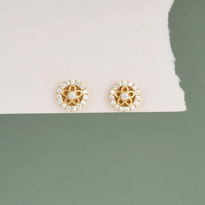 Close-up of S925 silver flower stud earrings with white zircons on a white card
