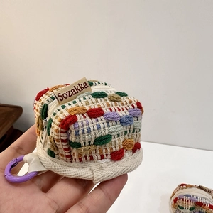 Macro detail of hand-knitted colorful earphone pouch with zip closure and purple carabiner