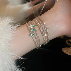 Macro detail of multilayer gold bracelet featuring marquise-cut gems and sparkling zircon stones
