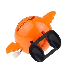 Macro view of orange wind-up bat toy with pumpkin face and wings for Halloween