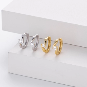 Detail of 925 sterling silver bypass hoop earrings with sparkling zircon stones