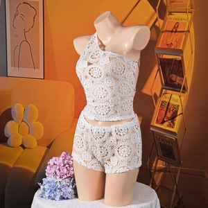 Dettaglio del set due pezzi in maglia bianca all'uncinetto con motivi floreali traforati