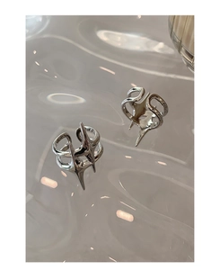 Macro shot of silver abstract star rings with polished finish on water-textured glass