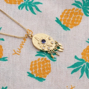 Gold-plated evil eye necklace with blue zircon pendant and geometric tassels