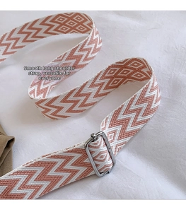 Close-up of adjustable woven shoulder strap with orange chevron pattern and silver buckle
