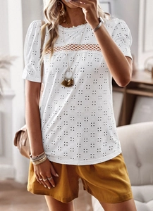 Detail showing white eyelet embroidery and intricate lace patchwork on the short sleeve top