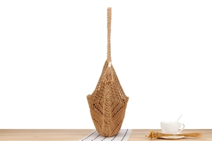 Detail of camel hand-woven hollow shoulder bag with fringe tassel and thick strap