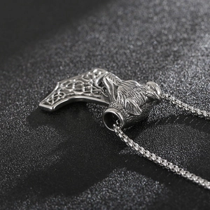 Macro shot of silver viking wolf head Mjolnir pendant with Celtic knot details