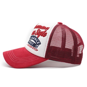 Close-up of red suede brim and 3D embroidery on white trucker mesh baseball cap