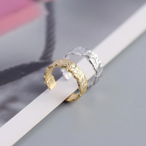 Close-up of gold and silver S925 sterling silver open rings with irregular foil texture