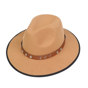 Detail of camel wool fedora hat featuring brown leather band and silver metal rivets